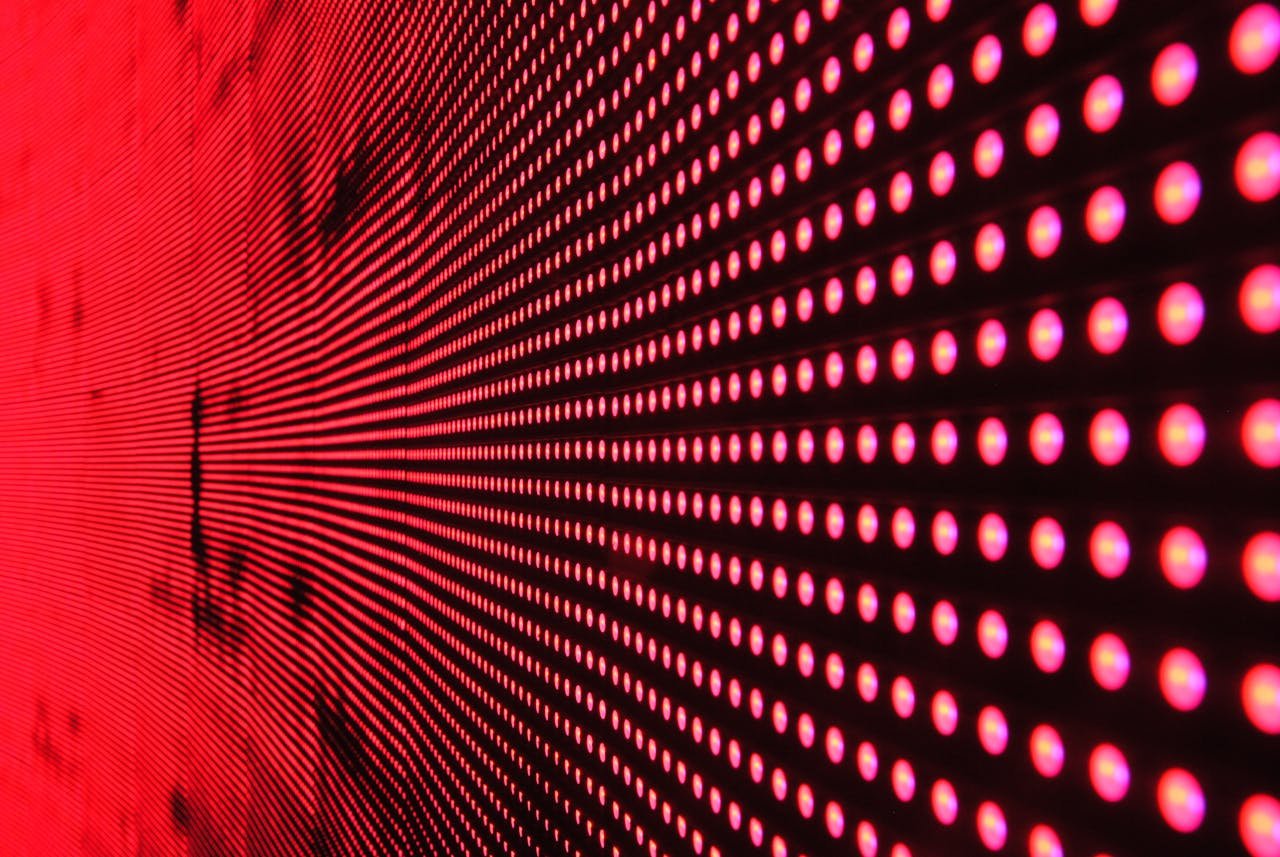 gallery-01 Vibrant abstract pattern of illuminated red LED lights forming a dynamic design.